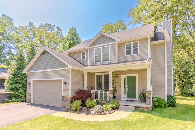 craftsman-style home featuring a garage, a front lawn, and covered porch