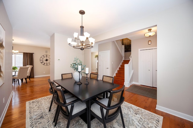 dining area featuring hardwood / wood-style flooring and an inviting chandelier