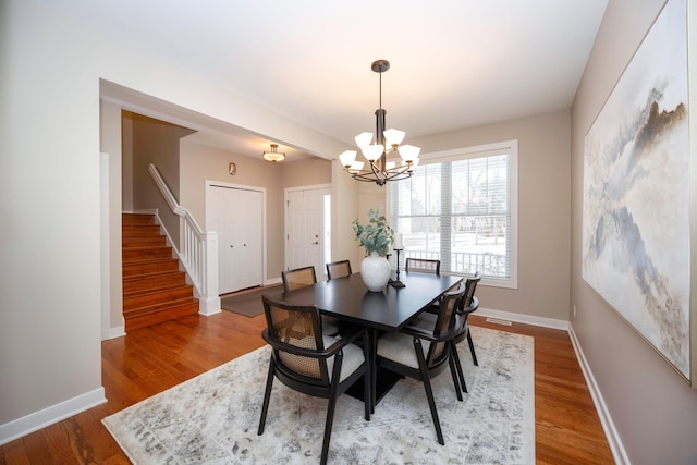 dining area featuring an inviting chandelier and hardwood / wood-style flooring