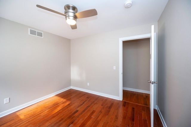 empty room featuring ceiling fan and dark hardwood / wood-style flooring