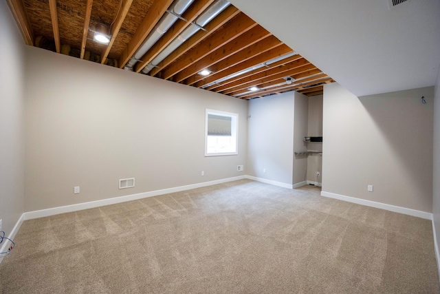 basement featuring light colored carpet