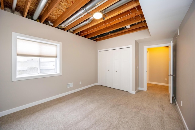 unfurnished bedroom with light carpet and a closet