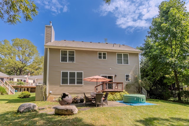 rear view of house with a wooden deck and a yard