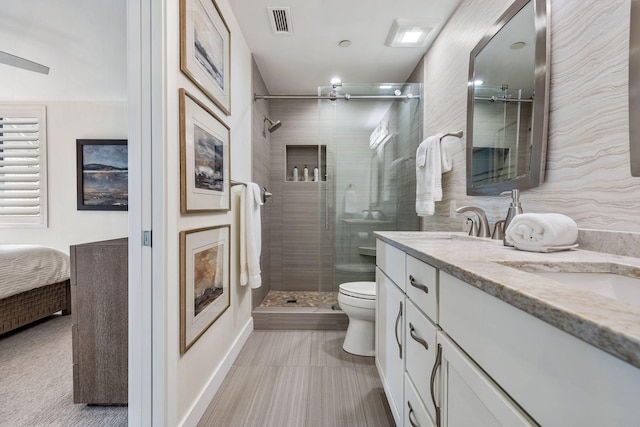 bathroom featuring vanity, toilet, and walk in shower