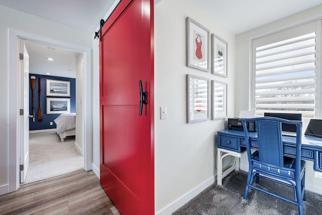 office space with wood-type flooring and a barn door