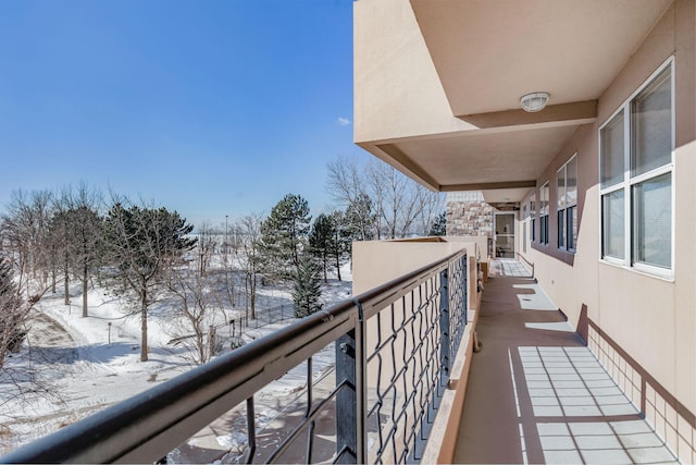 view of snow covered back of property