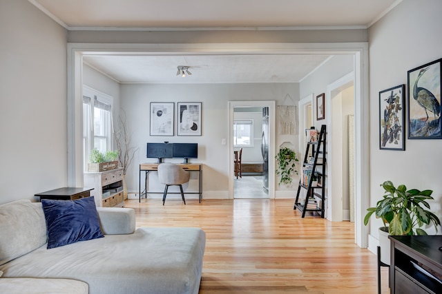 living room featuring baseboards, crown molding, and wood finished floors