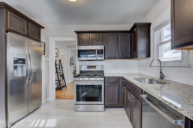 kitchen featuring dark brown cabinets, appliances with stainless steel finishes, and a sink