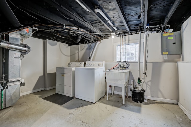 basement featuring heating unit, washing machine and clothes dryer, a sink, electric panel, and baseboards