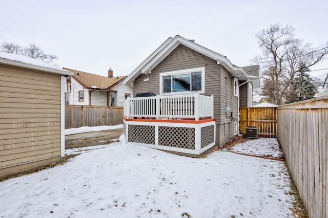 snow covered property featuring a fenced backyard and a wooden deck