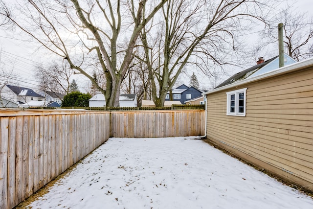 yard layered in snow featuring fence private yard and a residential view