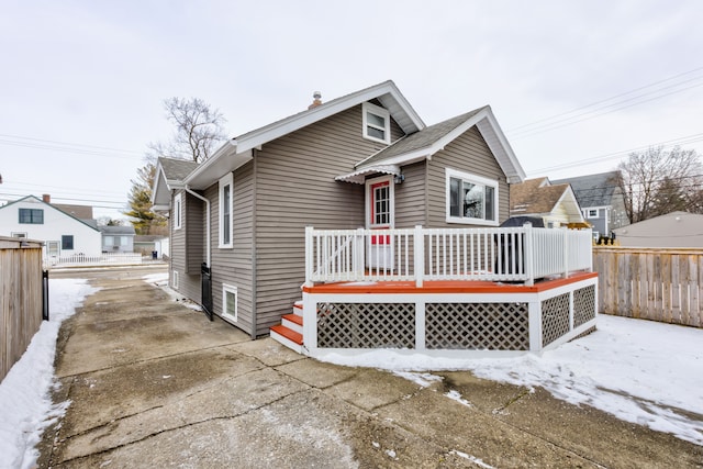 bungalow-style home featuring fence and a deck