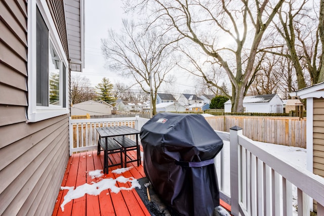 wooden deck with area for grilling, fence, and a residential view