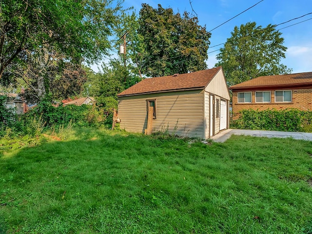 view of home's exterior with an outbuilding, a garage, and a lawn