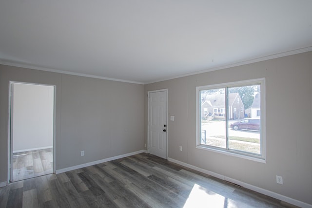 spare room featuring crown molding and dark wood-type flooring