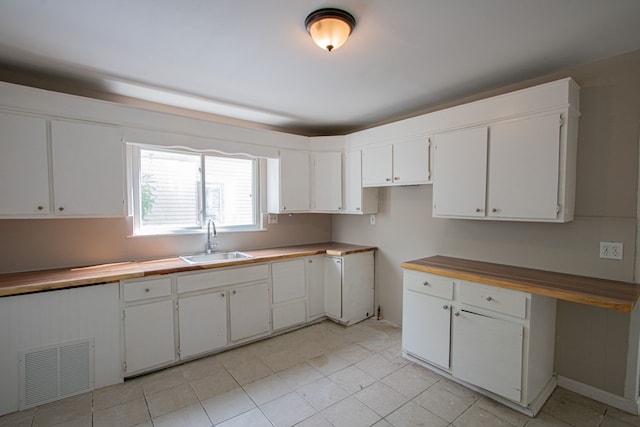 kitchen featuring white cabinetry, sink, and light tile patterned floors