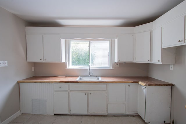 kitchen with white cabinetry, sink, and light tile patterned floors