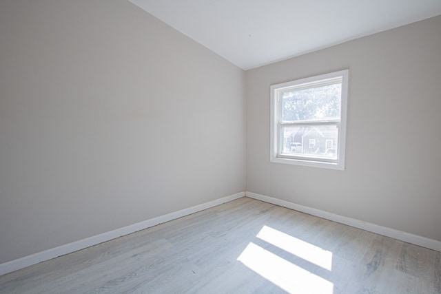 empty room featuring lofted ceiling and light hardwood / wood-style flooring