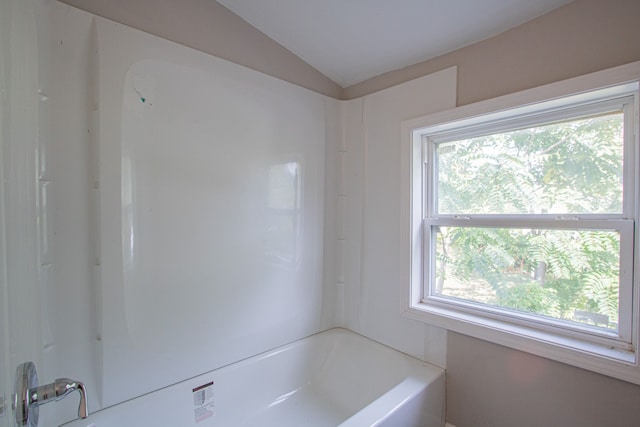 bathroom with bathtub / shower combination and vaulted ceiling