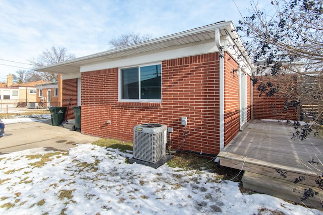 view of snow covered exterior featuring central AC unit