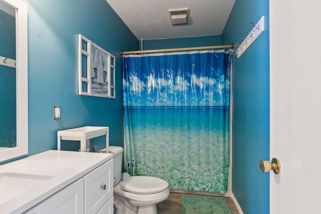 bathroom with hardwood / wood-style flooring, vanity, toilet, and curtained shower