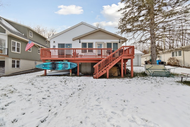 snow covered rear of property with a wooden deck