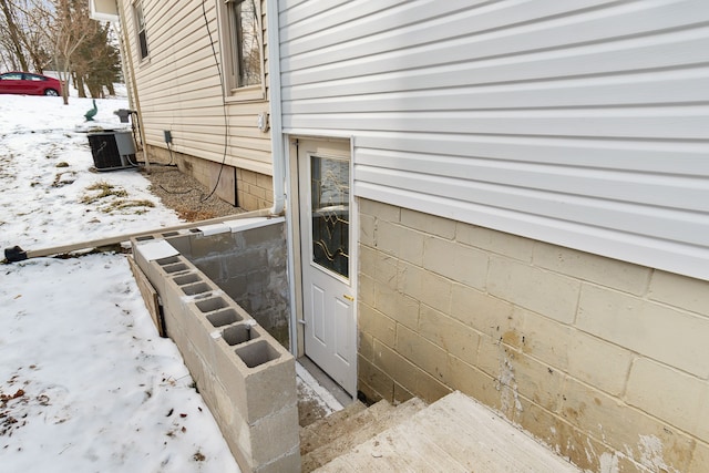 snow covered property entrance featuring cooling unit