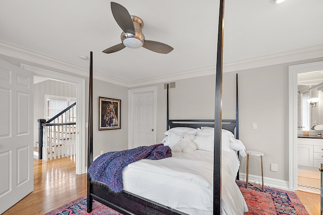 bedroom with multiple windows, ornamental molding, connected bathroom, and light hardwood / wood-style flooring