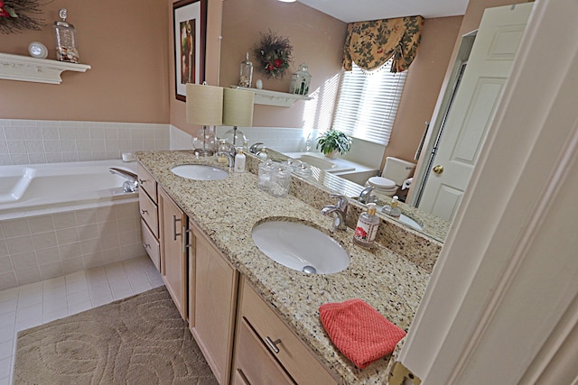 bathroom featuring vanity, tiled bath, and tile patterned flooring