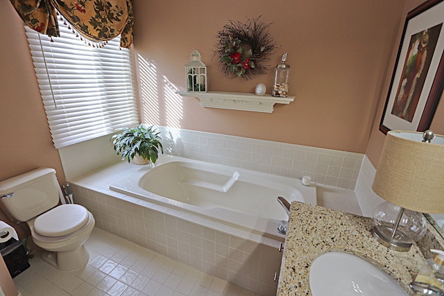 bathroom featuring a relaxing tiled tub, vanity, toilet, and tile patterned flooring