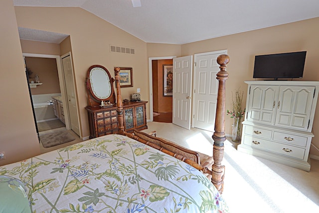 bedroom featuring carpet floors, ensuite bath, and vaulted ceiling