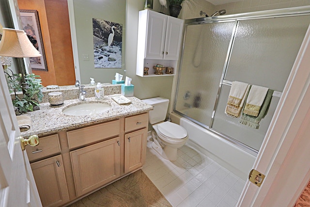 full bathroom featuring tile patterned flooring, enclosed tub / shower combo, vanity, and toilet