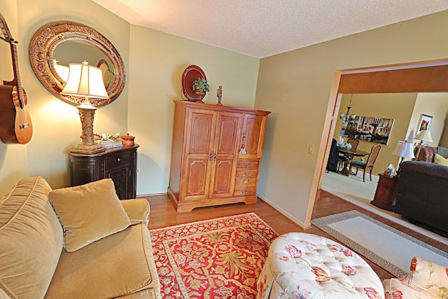 living room featuring light hardwood / wood-style flooring and a textured ceiling