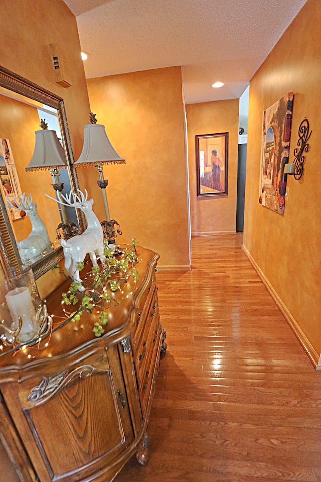 hall featuring wood-type flooring and a textured ceiling