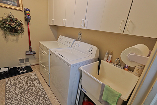 laundry room featuring cabinets, washer and clothes dryer, and sink