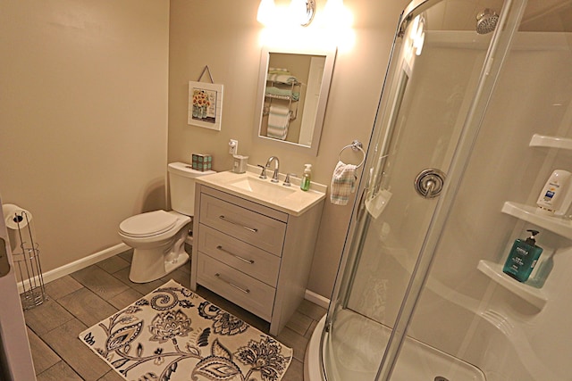 bathroom with a shower with door, vanity, and toilet