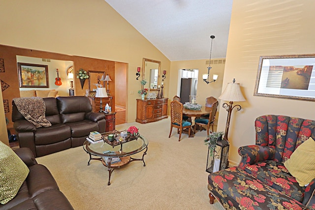 carpeted living room featuring an inviting chandelier and high vaulted ceiling