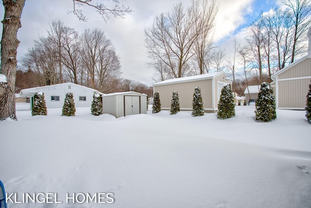 yard covered in snow featuring a shed