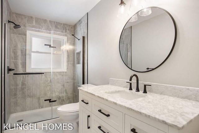 bathroom featuring vanity, toilet, and an enclosed shower