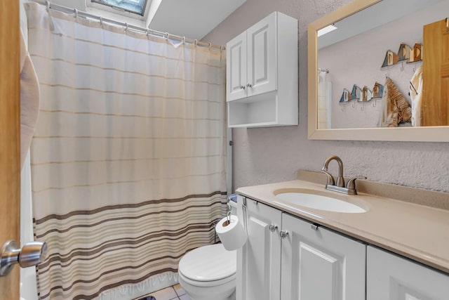 bathroom featuring vanity, curtained shower, a skylight, and toilet