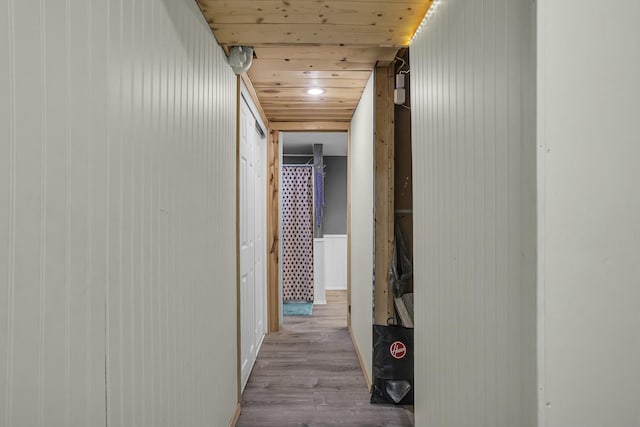 hallway featuring light hardwood / wood-style floors and wooden ceiling