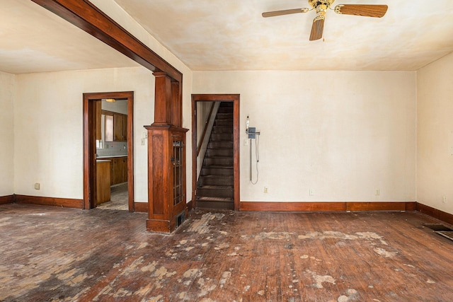 spare room with dark hardwood / wood-style flooring, ceiling fan, and ornate columns