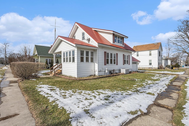 snow covered rear of property with a lawn