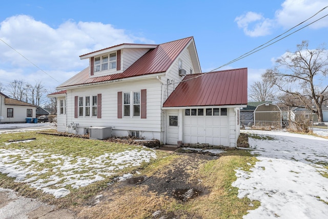 snow covered property with a garage