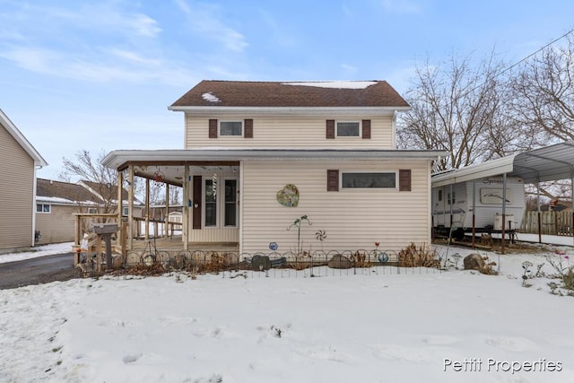 view of snow covered back of property