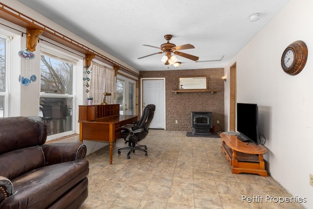 home office featuring a wood stove and ceiling fan