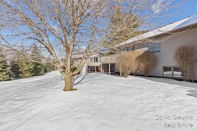 yard covered in snow featuring a deck