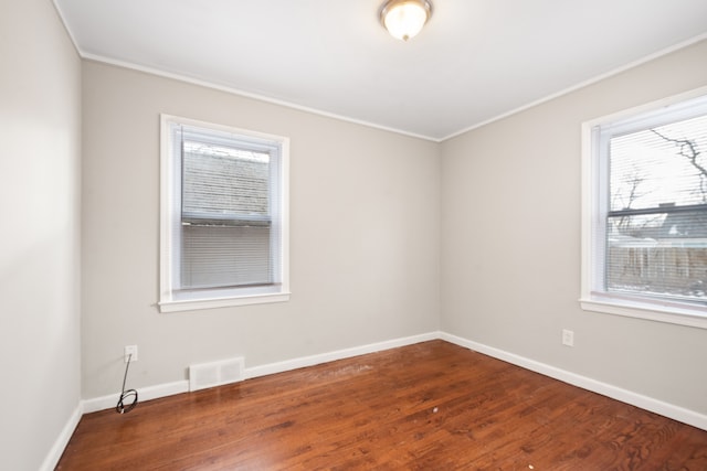 empty room with crown molding and hardwood / wood-style flooring