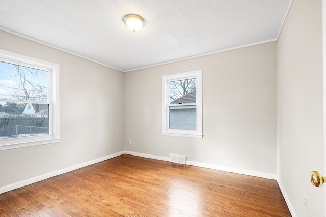 spare room featuring ornamental molding and hardwood / wood-style floors