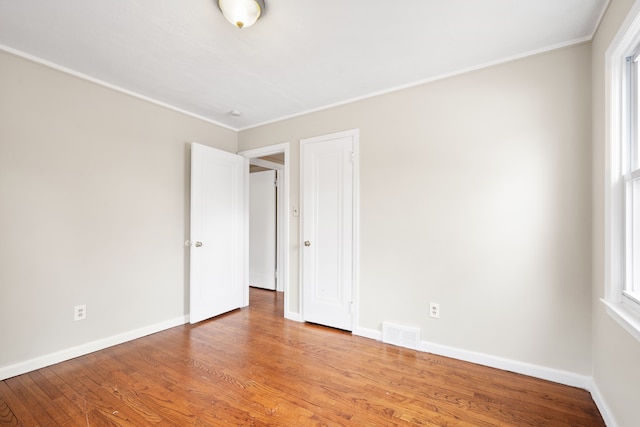 unfurnished room with a healthy amount of sunlight and hardwood / wood-style floors